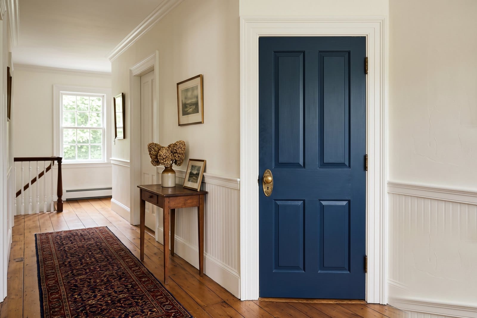 Paneled interior door painted a deep statement color against neutral walls in a MetroWest Boston older home
