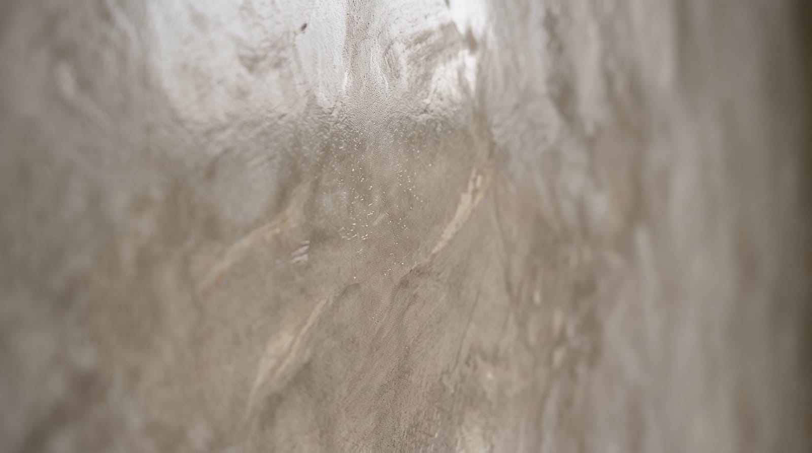 Close-up of a burnished Venetian plaster wall showing the subtle mottled depth and marble-like sheen