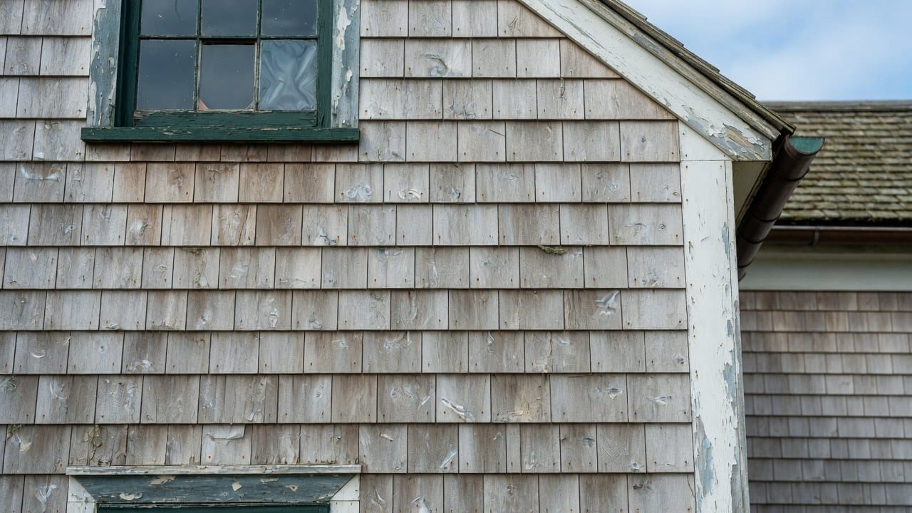 Weathered cedar clapboard siding on an older New England home due for paint renewal in Massachusetts