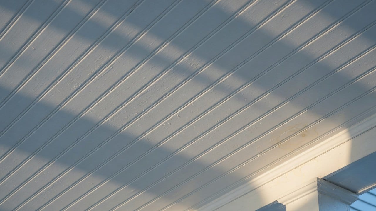 Detail of painted beadboard porch ceiling grooves, satin exterior acrylic, raking light, MetroWest colonial