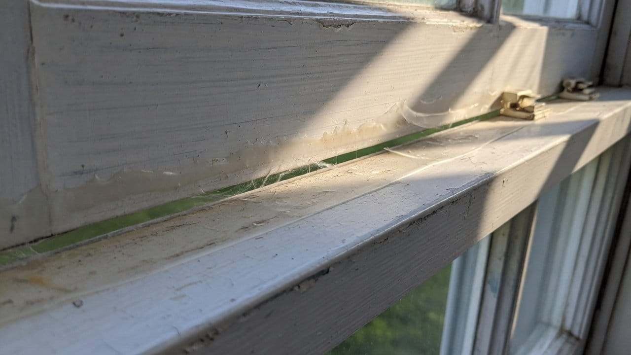 Close-up of a painted wood meeting rail on an older MetroWest double-hung, thin film, operable gap
