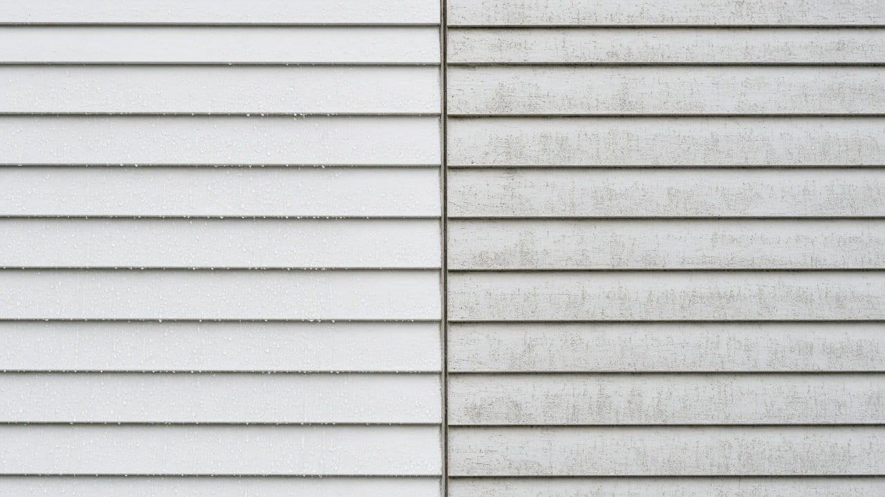 Half-washed siding wall showing clean section beside chalked section on a Massachusetts home